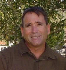 Shane LeBlanc wearing a brown shirt and smiling